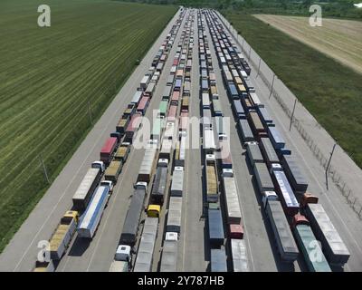 Lunga coda di camion nel porto al terminal. Vista dall'alto del parcheggio in attesa di scarico Foto Stock