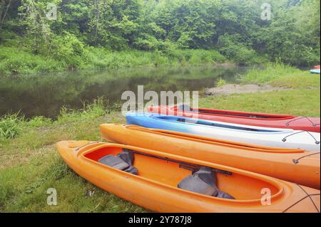 Quattro kayak sulla riva del fiume, kayak sportivi sulla riva dello stagno Foto Stock