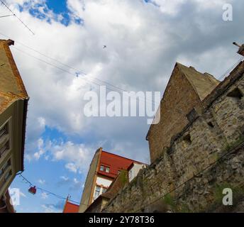 Cluj-Napoca, Romania. 26 aprile 2024: Un aereo passeggeri commerciale vola sul cielo sopra la parte del muro di difesa (XV secolo) del m Foto Stock