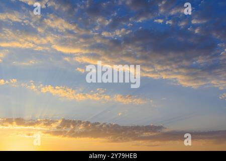 Alba presto con nuvole sparse e raggi del sole. Il cielo all'alba, quando i raggi di luce si infrangono attraverso le nuvole sparse Foto Stock