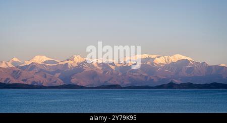 Panorama panoramico ad alta quota del lago Karakul all'alba, con la catena montuosa Trans-Alai innevata, Murghab, Gorno-Badakhshan, Tagikistan Foto Stock