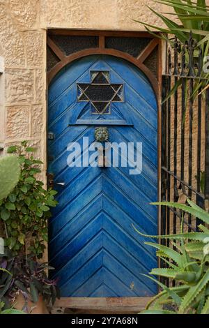 Primo piano di una porta di legno piena, pittoresca e blu su una casa nel quartiere Yemin Moshe di Gerusalemme, Israele. Foto Stock