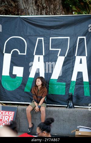 Cairns, Australia. 29 settembre 2024. Un bambino ascolta un raduno di solidarietà con la Palestina all'Esplanade di Cairns. I manifestanti si sono riuniti all'Esplanade di Cairns per protestare come parte di una giornata nazionale d'azione a sostegno della Palestina, chiedendo un cessate il fuoco totale e che il governo australiano sancisca Israele. Ciò avviene dopo un anno di bombardamenti e accuse di crimini di guerra contro Gaza da parte delle forze armate israeliane, nonché di continua espansione dei coloni nella Cisgiordania occupata, come indagato dalle Nazioni Unite, dalla Croce Rossa, da Amnesty International e da altre entità. Credito: Foto Stock