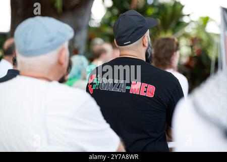 Un uomo indossa una t-shirt che rappresenta Gaza Med, un'organizzazione iniziata da medici australiani per assistere coloro che si trovano in Palestina durante l'occupazione israeliana e i bombardamenti durante un raduno all'Esplanade di Cairns. I manifestanti si sono riuniti all'Esplanade di Cairns per protestare come parte di una giornata nazionale d'azione a sostegno della Palestina, chiedendo un cessate il fuoco totale e che il governo australiano sancisca Israele. Ciò avviene dopo un anno di bombardamenti e accuse di crimini di guerra contro Gaza da parte delle forze armate israeliane, così come la continua espansione dei coloni nella Cisgiordania occupata come indagato dall'uni Foto Stock