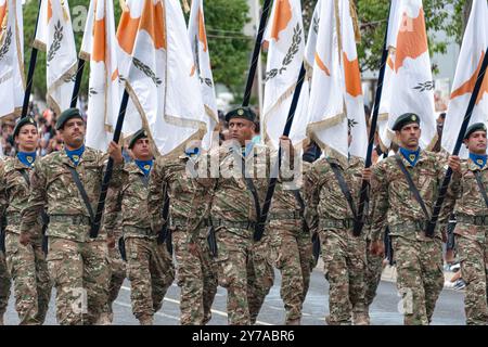 Nicosia, Cipro - 1 ottobre 2023: I soldati della Guardia nazionale cipriota stanno marciando in perfetta formazione, portando con orgoglio la bandiera nazionale della CYP Foto Stock