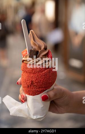 Trdelnik o trdlo è un dolce tradizionale ceco. Donna tiene a mano il trdlo in via Praga. Cibo di strada. Trdelnik è una torta dolce tradizionale con zucchero e. Foto Stock