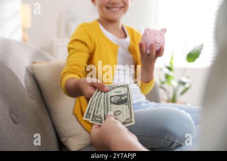 Madre che dà soldi a sua figlia a casa, primo piano Foto Stock