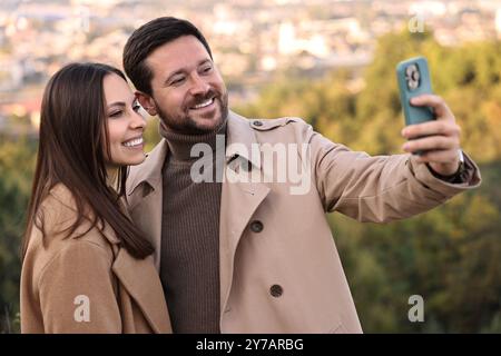 Bella coppia che fa selfie insieme all'aperto il giorno d'autunno Foto Stock