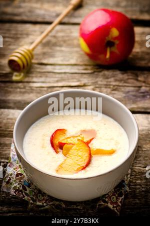 porridge con mele al caramello in una ciotola su un tavolo di legno. stile rustico. messa a fuoco selettiva Foto Stock