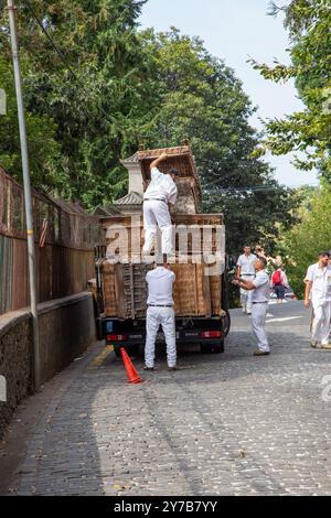 I corridori di cesti di vimini sull'isola portoghese di Madeira scaricano i loro cesti da un carro in preparazione per le giornate di slittino per i turisti Foto Stock