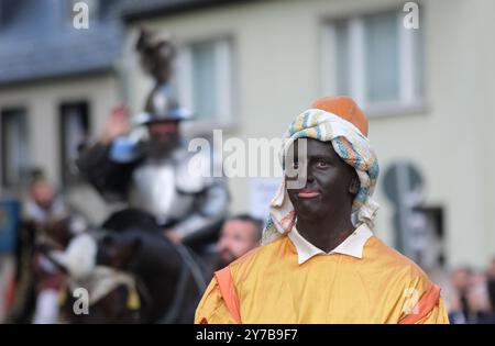 Mittweida, Germania. 29 settembre 2024. I partecipanti alla parata con un riferimento alla parata di epoca coloniale attraverso il centro della città alla fine del 25° Festival del raccolto di Stato. Lo spettacolo di tre giorni ha attirato decine di migliaia di visitatori nella città universitaria della Sassonia centrale. Il festival si terrà a Hoyerswerda l'anno prossimo. Crediti: Sebastian Willnow/dpa/ZB/dpa/Alamy Live News Foto Stock