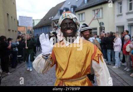 Mittweida, Germania. 29 settembre 2024. I partecipanti alla parata con un riferimento alla parata di epoca coloniale attraverso il centro della città alla fine del 25° Festival del raccolto di Stato. Lo spettacolo di tre giorni ha attirato decine di migliaia di visitatori nella città universitaria della Sassonia centrale. Il festival si terrà a Hoyerswerda l'anno prossimo. Crediti: Sebastian Willnow/dpa/ZB/dpa/Alamy Live News Foto Stock