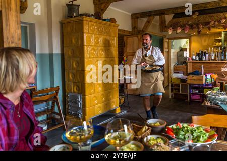 Lo chef René Bobzin prepara il pesce disossato con vari piatti di patate nella cucina del Bauernstube di Bobzin e li presenta personalmente al tavolo della cena. Dewichower Straße, Usedom-Süd, Meclemburgo-Vorpommern, Germania Foto Stock