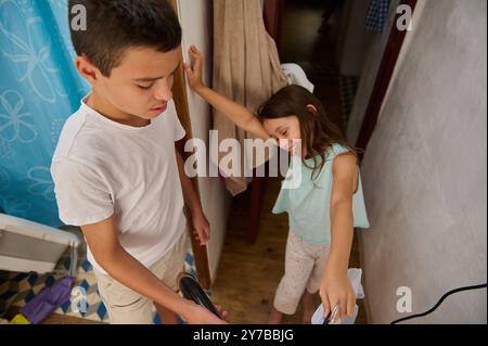 Un ragazzo e una ragazza, fratelli, giocheranno con gioia in un bagno caldo e invitante, che mostra legami familiari. Foto Stock