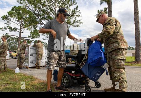 Contea di Suwannee, Stati Uniti. 28 settembre 2024. U.S. Army SFC. Justin Ferrell, giusto, con la Guardia Nazionale della Florida distribuisce cibo e rifornimenti per aiutare i sopravvissuti dopo l'uragano Helene, il 28 settembre 2024 nella Contea di Suwannee, Florida. La contea di Suwannee lungo la regione di Big Bend ha ricevuto il peso dell'uragano di categoria 4. Crediti: PFC. Eli Johnson/US Army/Alamy Live News Foto Stock
