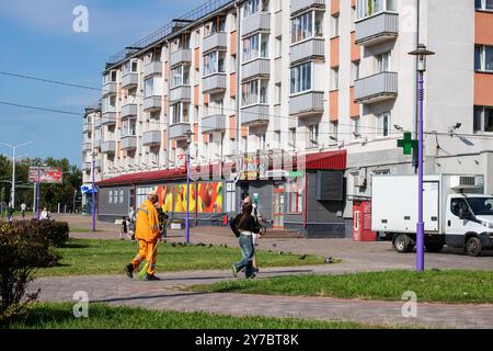 Bielorussia, Minsk - 18 luglio 2024: Un grande camion bianco è parcheggiato comodamente di fronte a un edificio con un simbolo di croce verde Foto Stock