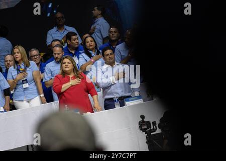 San Juan, Stati Uniti. 22 settembre 2024. Il Commissario Jenniffer González Colón e suo marito, José Yovin Vargas Llavona, tengono le mani a cuore mentre ascoltano l'inno nazionale degli Stati Uniti durante l'assemblea generale del nuovo Partito Progressista a San Juan, Porto Rico, domenica 22 settembre 2024. Crediti: SIPA USA/Alamy Live News Foto Stock