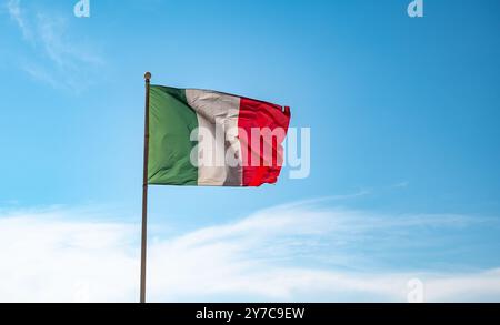 Bandiera italiana che ondeggia su sfondo blu del cielo. Foto Stock