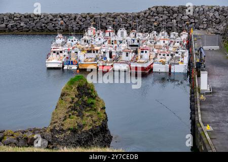 Tranquillo porto costiero con barche da pesca attraccate lungo lo Stone Pier in un giorno coperto - tranquilla scena marittima perfetta per temi nautici e costieri, Foto Stock