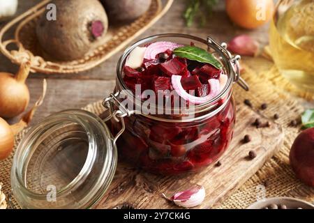 Preparazione di barbabietole fermentate fatte in casa in un vaso di vetro a base di barbabietole fresche, cipolle, aglio e spezie Foto Stock