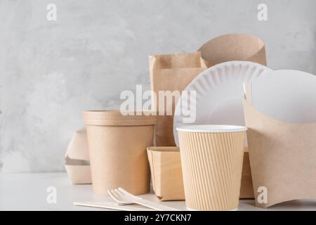 Stoviglie monouso ecologiche e biodegradabili in legno di bambù e carta kraft. Tazze, posate e contenitori per alimenti per consegne sostenibili e. Foto Stock