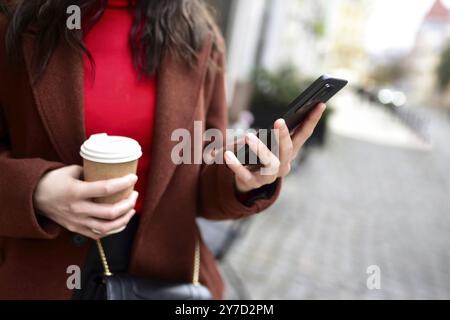 Smartphone in mano alla donna sullo sfondo della strada Foto Stock