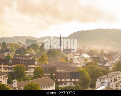Villaggio con torre della chiesa e molte case, colline sullo sfondo, nebbia mattutina, vista aerea del pittoresco paesaggio, Calw, Foresta Nera, Germania Foto Stock