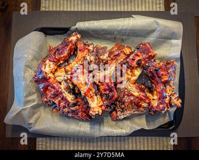 Succulente costolette di maiale alla griglia rivestite in una ricca glassa affumicata, grigliate alla perfezione al barbecue Foto Stock