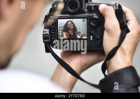 Digital single lens reflex in mani. Fotografo mani riprese da vicino. L'uomo fotografo rende le foto per la fotografia stock. Maschio di tenere le mani Foto Stock