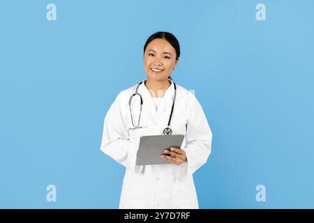 Operatore sanitario sorridente in un cappotto bianco che tiene una compressa Foto Stock