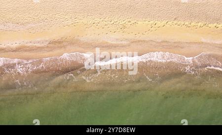 Vista aerea della spiaggia di sabbia. Vista dall'alto sulle onde del mare. Riprese con droni Foto Stock