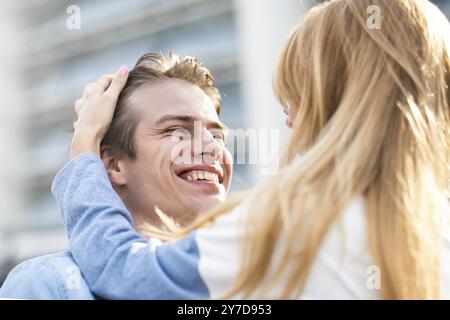 Felice di passare del tempo insieme. Giovane, bella coppia, ritratto di moda all'aperto. Un ragazzo e una ragazza attraenti che abbracciano e si baciano Foto Stock