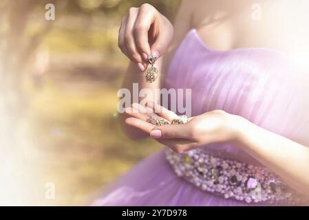 Gioielli da sposa in mani femminili da vicino. abito vintage. moda Foto Stock