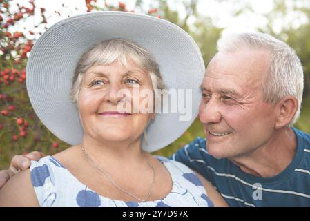 Autentico scatto all'aperto di coppie anziane che si divertono in giardino e benedetti con amore. Concetto di amore Foto Stock