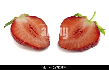 Due metà di fragole isolate su sfondo bianco. Bacche rosse fresche in taglio, messa a fuoco completa Foto Stock