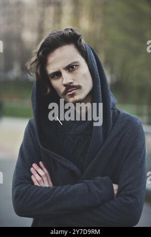 Bel giovane uomo riccio in posizione difensiva. La vista è sospetta Foto Stock