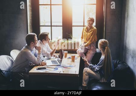 Gruppo di colleghi aventi riuniti nella sala riunioni mentre si lavora su una presentazione di grandi dimensioni e la preparazione della loro strategia commerciale. Progettisti creativi cercando br Foto Stock