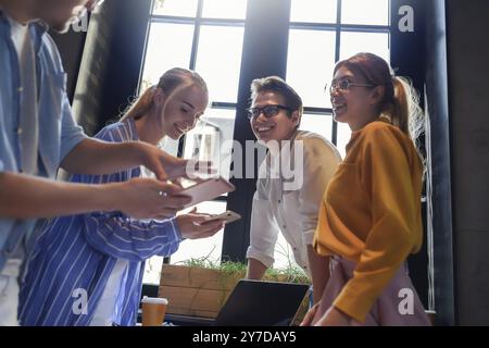 Gruppo di colleghi aventi riuniti nella sala riunioni mentre si lavora su una presentazione di grandi dimensioni e la preparazione della loro strategia commerciale. Progettisti creativi cercando br Foto Stock