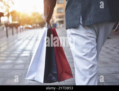 Primo piano di un giovane caucasico che tiene in strada dei sacchetti di carta diversi Foto Stock