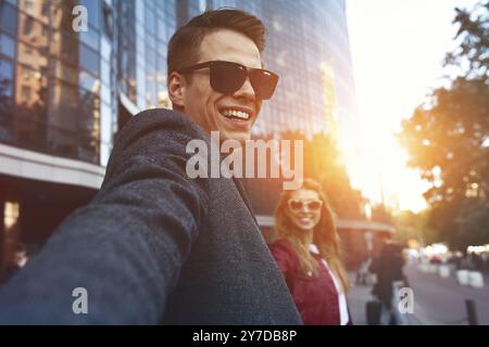 Bella coppia giovane e amorevole che porta borse della spesa e si diverte insieme. Immagine che mostra lo shopping di una giovane coppia in città Foto Stock