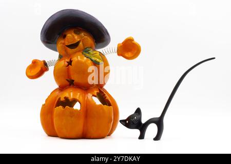 Jack o Lanterna e una statuetta nera di gatto. Portacandele in ceramica a forma di zucca di halloween. Carino spettacolo di halloween Foto Stock