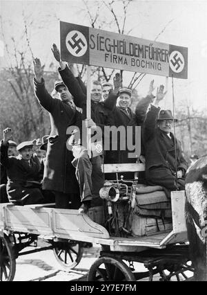 I dipendenti della firma Bochig, con in mano un cartello di legno "Sieg Heil to the Fuehrer", danno il saluto nazista dal loro carro trainato da cavalli. Sono tra i celebranti viennesi che sono venuti ad accogliere l'arrivo delle truppe tedesche in città. La foto è datata 14 marzo 1938. Foto Stock