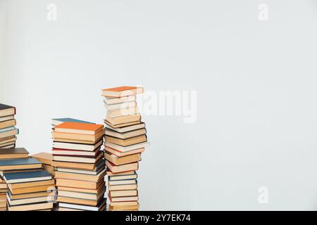 Pile di libri per insegnare in biblioteca su sfondo bianco Foto Stock