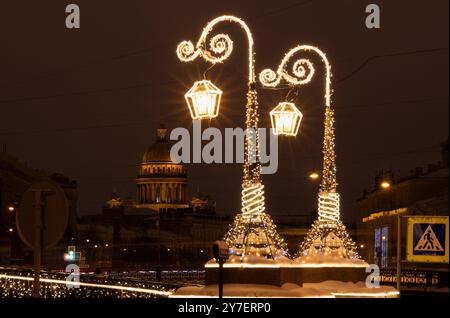 Due lampioni con raggi e illuminazione notturna e la cattedrale di Sant'Isacco sullo sfondo (San Pietroburgo, Russia) Foto Stock