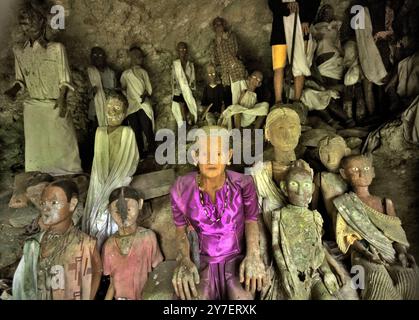 Il legno effige all'interno di una grotta in un sito di sepoltura tradizionale nel villaggio di Kete Kesu, Toraja Nord, Sulawesi Sud, Indonesia. Foto Stock