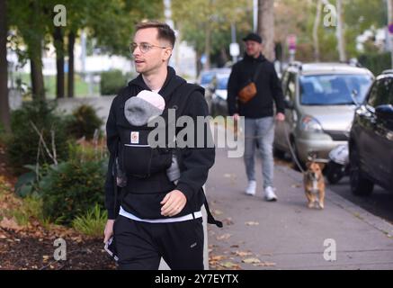 Vienna, Austria. 29 settembre 2024. Un elettore che trasporta un bambino (davanti) cammina fino a una stazione elettorale a Vienna, Austria, 29 settembre 2024. I primi risultati delle elezioni parlamentari austriache tenutesi qui domenica hanno dimostrato che il Partito della libertà di estrema destra sta guidando il voto nazionale e si è assicurato la sua prima vittoria elettorale generale, secondo i resoconti dei media. Credito: He Canling/Xinhua/Alamy Live News Foto Stock