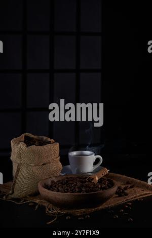 macinacaffè, fotografato sullo sfondo di un'ombra della finestra e posizionato su un vassoio, un piccolo cucchiaio di caffè per raccogliere i chicchi di caffè Foto Stock