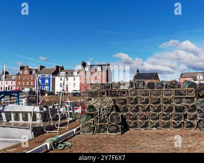 Pile di creme per la pesca di aragoste e granchi impilate sulla tradizionale banchina in pietra e acciottolata del porto di pesca di Arbroath. Foto Stock