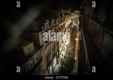 Rua do Carmo illuminata di notte dall'Elevador de Santa Justa Walkway - Lisbona, Portogallo Foto Stock