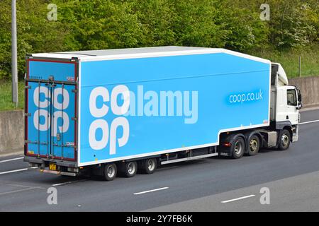 Logo del marchio commerciale cooperativo sulla vista delle portiere laterali e posteriori semi-rimorchio blu dietro il camion semi-trattore DAF hgv bianco sull'autostrada M25 Essex Inghilterra Regno Unito Foto Stock